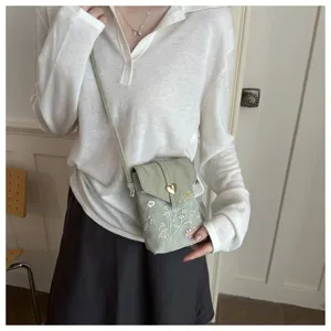 Borsa a tracolla per telefono verde ricamata con chiusura in metallo e motivi floreali.