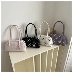 Detail shot of stylish polka dot bowling shoulder bags in multiple colors with star pendants.