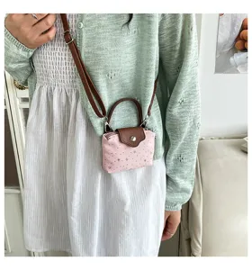 Detail view of a cute pink mini crossbody bag with brown handle and star pattern.