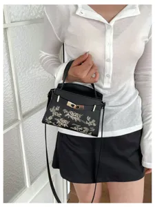 Elegant black women handbag with floral embroidery and metal lock, perfect for daily wear.