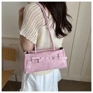 Detailed view of the pink shoulder underarm bag featuring decorative belt and metal eyelets.