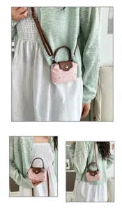 Detailed view of the pink star pattern mini crossbody bag with brown straps and top handle.