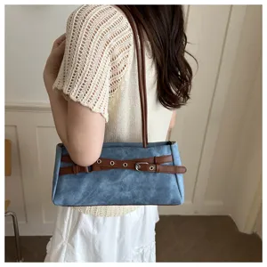 Blue denim shoulder bag with brown belt detail, stylish underarm handbag for women.