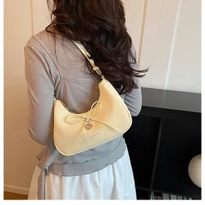 Vue de détail de l'élégant sac à épaule jaune clair de femme avec un joli nœud.