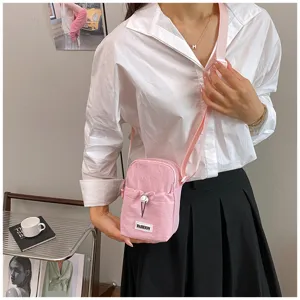 Mini pink crossbody canvas bag detail, casual shoulder bag with adjustable strap for women.