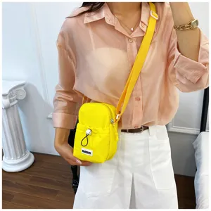 Mini crossbody bag detail, bright yellow fabric, adjustable strap, daily casual wear.
