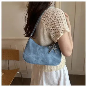 Blue shoulder hobo bag detail view, featuring soft suede texture and elegant rhinestone bow.