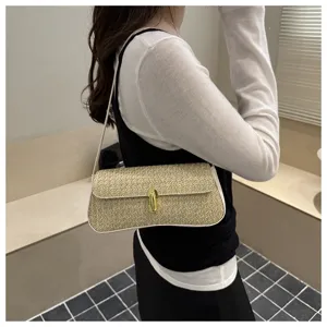 Detailed view of the stylish straw shoulder bag featuring a chic gold metal lock clasp.