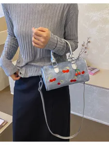 Stylish denim Boston shoulder bag with cute cherry embroidery and chic silver handle.