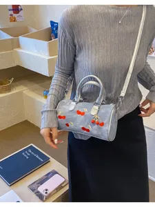 Light blue denim boston shoulder bag with cute cherry embroidery, silver handles and chic strap.