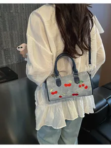 Denim Boston shoulder bag for women, chic cherry embroidery design with top handle and strap.