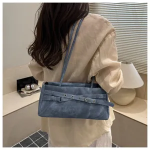 Detail view of blue denim shoulder bag with stylish belt buckle design, ideal for daily wear.