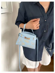 Light blue women handbag with exquisite gold embroidery and lock detail for daily fashion style.