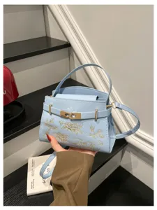 Light blue women handbag with gold embroidery and metal lock, elegant design for daily use.