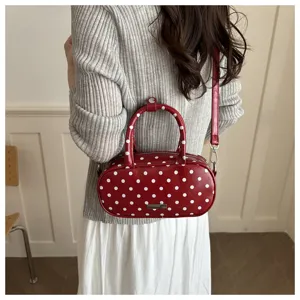 Red polka dot handbag for women, cute shoulder bag and travel cosmetic pouch with top handle.