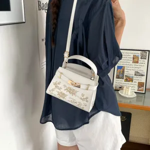 Elegant white top-handle crossbody bag with gold hardware and floral print for women