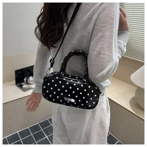 Black and white polka dot cosmetic bag lifestyle detail shot showcasing stylish crossbody.