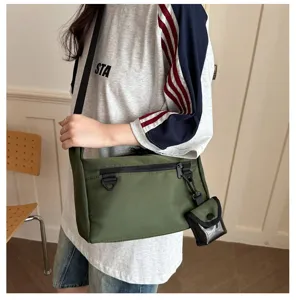 Casual green nylon crossbody messenger bag with front zipper pocket and small detachable pouch.