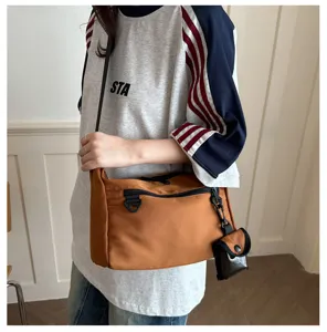 Casual nylon shoulder messenger bag featuring adjustable strap and mini coin purse accessory item.