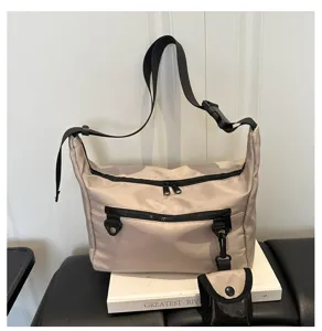 Detail view of stylish large capacity nylon crossbody bag with zipper pockets and small pouch.