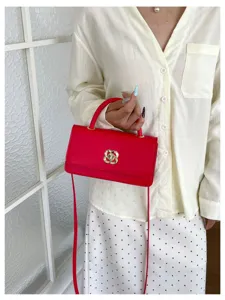 Borsa a tracolla rossa chic da donna in pelle con elegante chiusura a torsione floreale.