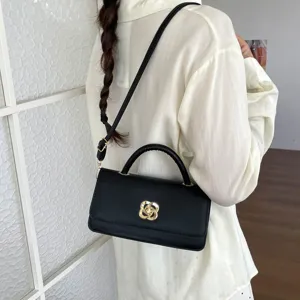 Elegante borsa a tracolla nera da donna, borsa baguette alla moda con chiusura dorata.