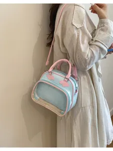 Vue détaillée d'un sac ita pastel bleu et rose avec fenêtre transparente pour vos accessoires.