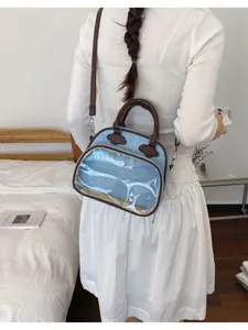 Vue détaillée du joli sac transparent bleu clair avec poignée marron et bandoulière.