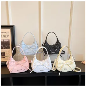 Detail view of stylish dumpling crossbody bags with star patterns, bow decor and metallic logo.