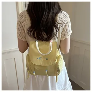 Vista detallada de la mochila casual de mujer con cordones de cuentas y diseño bordado.
