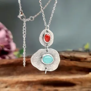Gros plan d'un collier en acier inoxydable style bohème avec pendentifs doubles.