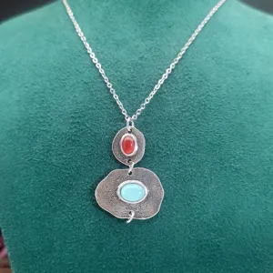 Collier en acier inoxydable style bohème avec pendentif calcédoine et corail rouge.