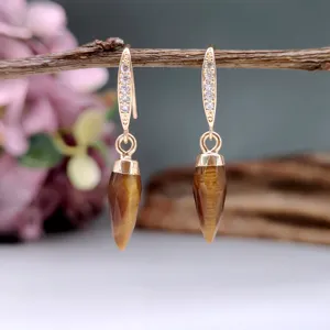 Primo piano dettaglio di orecchini vintage in pietra naturale con gancio in zirconio.