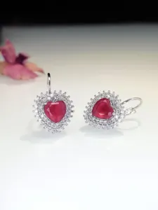 Dettagliata vista di eleganti orecchini a cuore rosso con luminoso contorno di zirconi.