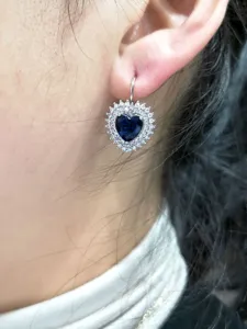 Primo piano dettagliato di splendidi orecchini a cuore in zircone blu con pratico gancio francese.