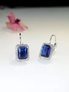 Eleganti orecchini pendenti con pietra blu centrale e zirconi luminosi di alta qualità.