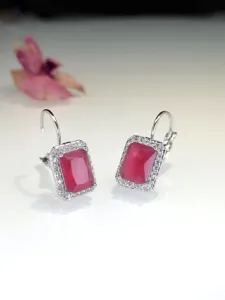 Primo piano di eleganti orecchini con gancio francese in zircone rosso rettangolare.