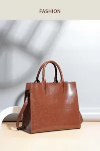 Detail view of premium brown leather tote bag, fine texture and durable shoulder strap.