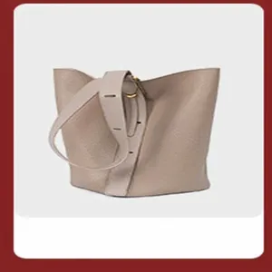 Beige leather bucket shoulder bag detail, soft touch commuter handbag closeup view.