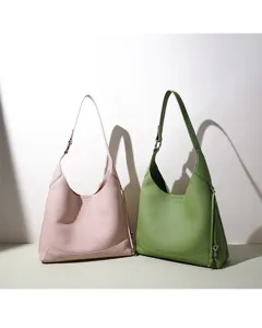 Vue détaillée de sacs hobo minimalistes en cuir rose et vert aux superbes finitions texturées.