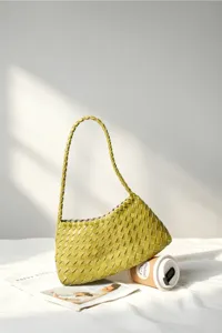 Green woven shoulder bag detail, stylish underarm handbag design for women daily commute.