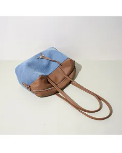 Vue détaillée du sac bandoulière en denim patchwork, design élégant en cuir bleu et marron.