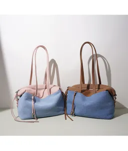 Vue détaillée du sac cabas élégant et tendance en denim et cuir avec des breloques clés.