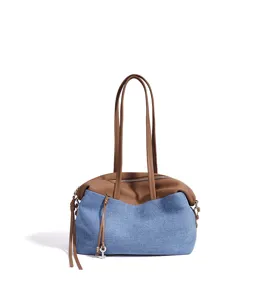 Vue détaillée du sac bandoulière en denim et cuir avec charmant pendentif clé.
