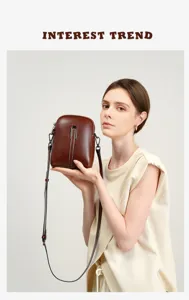 Detailed view of genuine leather mini crossbody phone bag in dark brown with metal clasp.