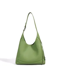 Détail de sac porté épaule hobo en cuir vert, sac à main minimaliste avec bandoulière réglable.