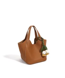 Détail de sac cabas en cuir marron avec coutures blanches et charm tulipe pour le quotidien.