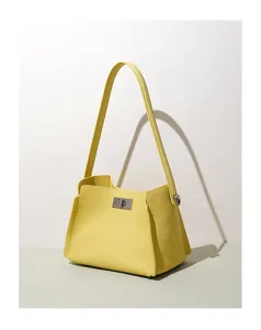 Detailed view of a stylish yellow leather shoulder bag with metallic turn-lock closure.