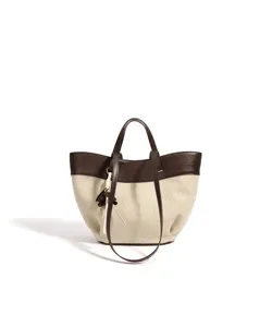 Detail view of the two-tone canvas leather tote bag with elegant dark brown trim and shoulder strap.