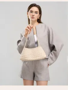 Detailed view of the beige woven leather handbag, highlighting fine texture and design.